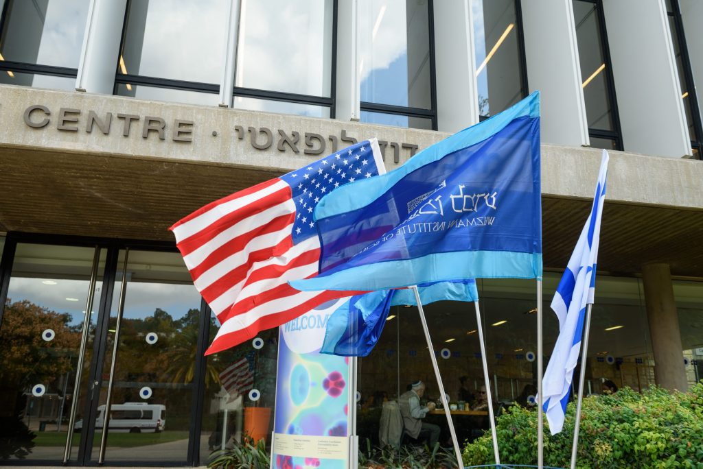 American flag and Technion flag in front of a building.